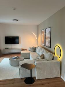 a living room with a couch and a table at REMA Homes - 180x200 Bett Küche Bad 50'' TV Tiefgarage in Offenburg