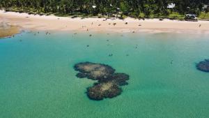 an island in the water next to a beach at Pousada Ponta da Baleia in Barra Grande