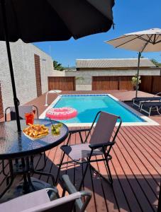 a patio with a table and chairs and a pool at Acomodação Cambirela in Palhoça