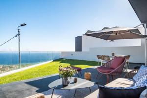 um pátio com uma mesa e cadeiras e vista para o oceano em Bayview Villa Retreat no Funchal