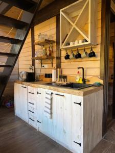 a kitchen with wooden cabinets and a sink at Villa Prive and Spa in Kopaonik