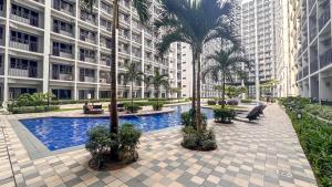 une cour avec des palmiers devant un immeuble dans l'établissement Oasis Urban Stay 2, à Manille