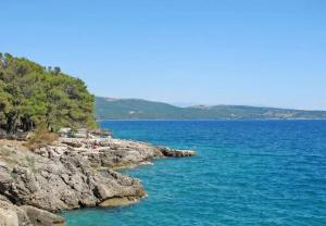 a group of people sitting on the rocks in the water at House Ana in Kornić