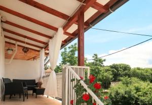 a patio with a white pergola and red flowers at House Ana in Kornić