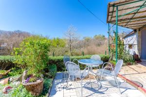 a patio with a table and chairs in a garden at House Ana in Kornić