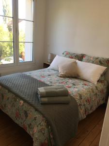 Un dormitorio con una cama con almohadas y una ventana. en Maison proche Disney & Paris, en Lagny