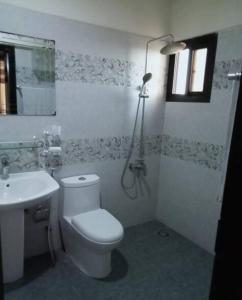 a bathroom with a white toilet and a sink at Luxury Apartment in Karachi