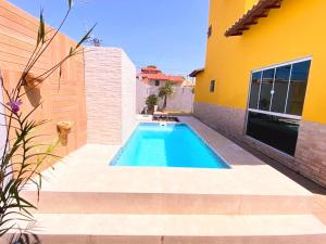 a swimming pool in the backyard of a house at Casa amarela 2km de Geribá-Buzios in Búzios