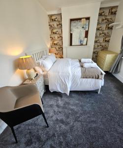 a bedroom with a bed and a couch and a chair at HARU Residence, 5bed Luxury House in London