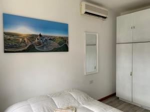 a bedroom with a bed and a painting on the wall at Apartamentos Colibrí- Frente al Santuario de la Virgen in San Nicolás de los Arroyos +74 photos