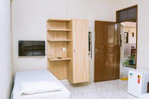 a bedroom with a bed and a tv and a door at Pousada e Hostel Casarão 2030 in Natal