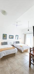 サン・ブラスにあるLa Familiaの白い壁の部屋にベッドが2つある