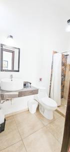 サン・ブラスにあるLa Familiaのトイレ、洗面台、鏡のあるバスルーム