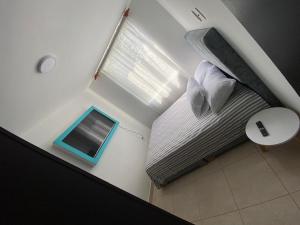 a small bed in a room with a window at Amplio apartamento 806 in Armenia