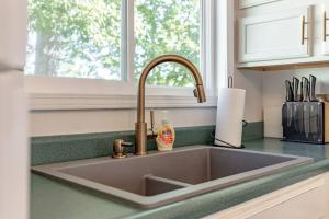 a kitchen sink with a soap dispenser next to a window at Lakefront Retreat-3bdrm 2ba with stunning views! Hiking & Fishing! in Falls of Rough +24 photos