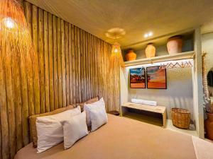 a bedroom with a bed with a wooden wall at Villa Aconchego - Casas de Luxo in São Miguel dos Milagres +33 photos