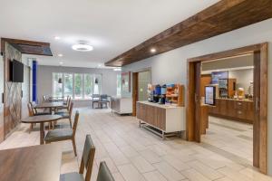 a waiting room with tables and chairs and a pharmacy at Holiday Inn Express Hotel and Suites Alice by IHG in Alice