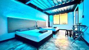 two beds in a room with blue lighting at Jardin Loft in Medellín