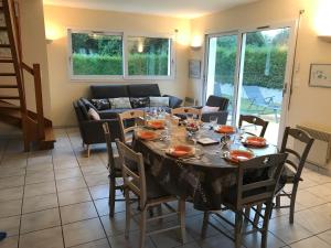a dining room with a table and chairs at Beg Meil in Fouesnant +5 photos