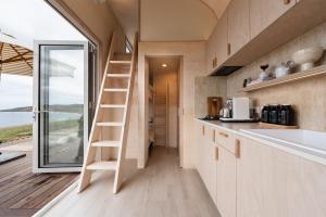 a tiny house with a ladder in a kitchen at Off-grid Beachfront Cabin on Kangaroo Island in North Cape
