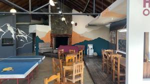 a dining room with tables and chairs and a fireplace at Hostel Otto Tipp in El Bolsón