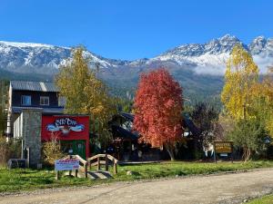 a building on the side of a road with mountains at Hostel Otto Tipp in El Bolsón