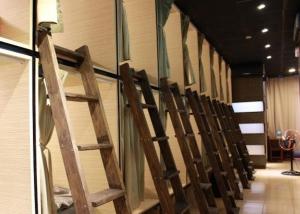 una fila di sedie in legno è allineata contro un muro di FC Hostel-Ruifang Station a Ruifang