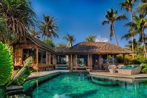 una villa con piscina y una casa en Sejuk Beach Villas, en Canggu