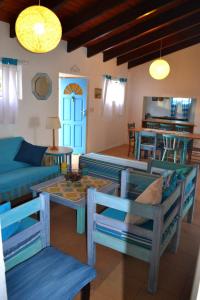 un salon avec un canapé bleu et une table dans l'établissement The Green Palm Cottage, à Plettenberg Bay