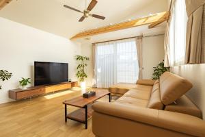 a living room with a couch and a flat screen tv at 鎌倉-Reihome in Kamakura