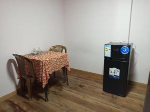una mesa con sillas junto a una nevera pequeña en Central Stay Departamentos III, en Oruro 5 fotos más
