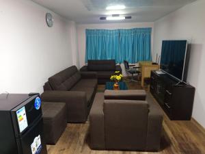Una sala de estar con un sofá y un televisor de pantalla plana. en Central Stay Departamentos III, en Oruro