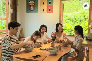 a group of people sitting around a wooden table at Toce House Tả van in Sapa