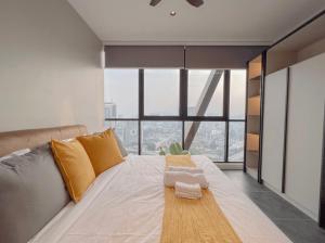 a large bed in a room with a large window at Scarletz Suites KLCC in Kuala Lumpur