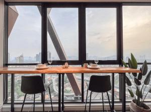 a table and chairs in front of a large window at Scarletz Suites KLCC in Kuala Lumpur