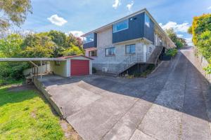 an empty driveway in front of a house at Tuis and Pools - Lake Taupo Holiday Home in Taupo