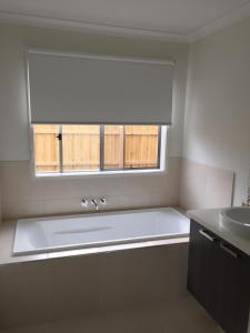 a bathroom with a large white tub and a window at London Park Resort in Narre Warren +26 photos