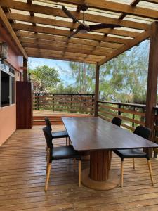 un tavolo e sedie in legno su una terrazza di legno di Studio ENORA a Punaauia