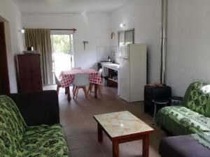 a living room with a table and a kitchen at Piriápolis La Perla in Playa Verde