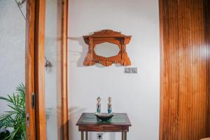 a table with a wooden shelf on a wall at Thousand Sunday Ubud in Ubud