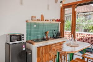 a kitchen with a sink and a table with a microwave at Thousand Sunday Ubud in Ubud