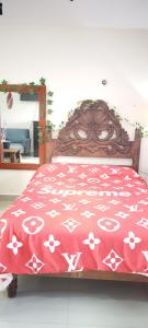 a bed with a red blanket with white flowers on it at Gacelita Cozumel in Cozumel