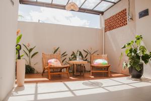 a patio with two chairs and a table and some plants at Thousand Sunday Ubud in Ubud