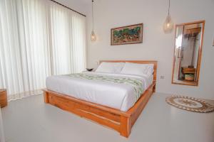 a bedroom with a bed and a large window at Thousand Sunday Ubud in Ubud