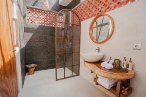 a bathroom with a sink and a mirror at Thousand Sunday Ubud in Ubud