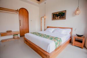 a bedroom with a large white bed in a room at Thousand Sunday Ubud in Ubud