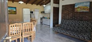 a kitchen with a table and chairs and a brick wall at Cabañas La Esperanza Del Valle in Valle Grande