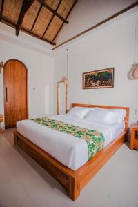 a bedroom with a large bed in a room at Thousand Sunday Ubud in Ubud