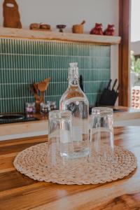 two glasses and a bottle on a plate on a table at Thousand Sunday Ubud in Ubud