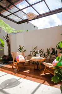 a patio with chairs and a table and a window at Thousand Sunday Ubud in Ubud